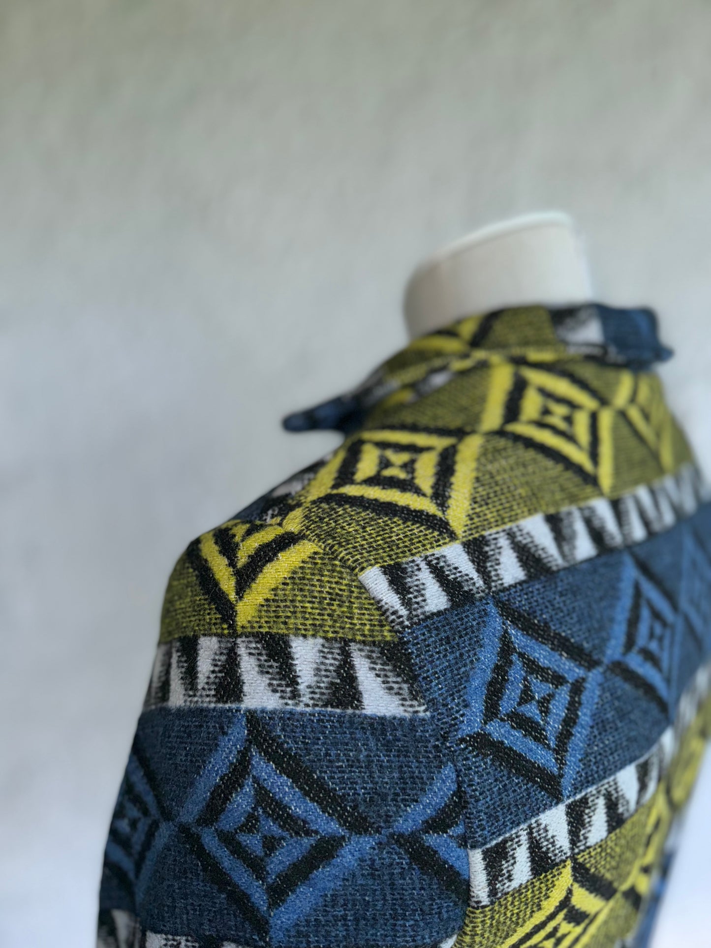 close up of the shoulder stitching and fabric texture of the blue and blue yellow one of a kind short jacket